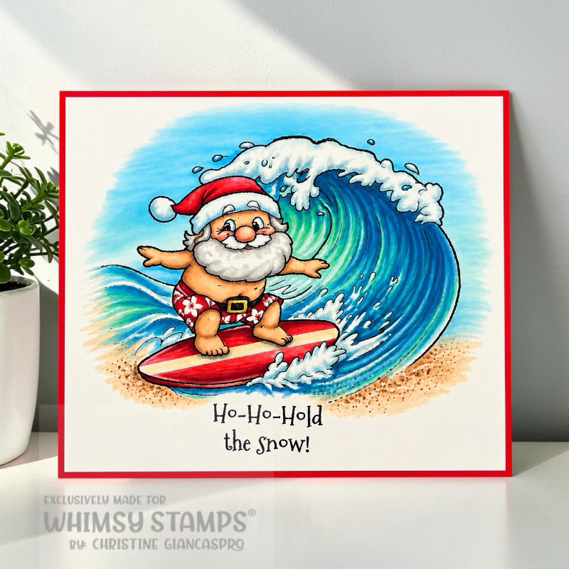 A square art handmade card featuring a whimsical Santa Claus surfing on a large blue wave, with the text 'Ho-Ho-Hold the snow!' at the bottom. The image panel is mounted on a red card base.