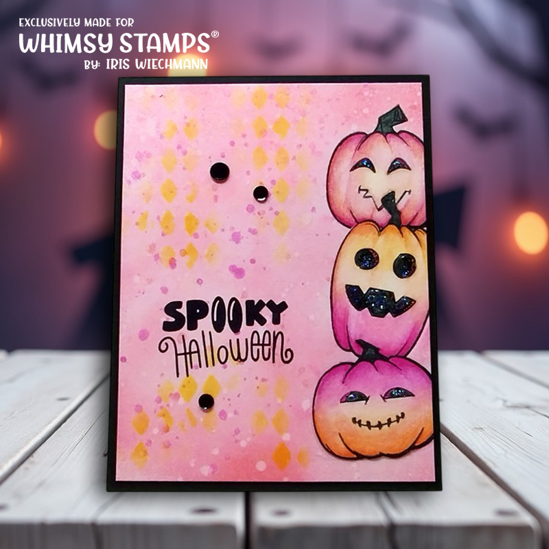 A handmade Halloween card with three stacked jack-o'-lanterns in pink and orange, on a pink watercolor background with yellow speckles and the text 'Spooky Halloween'.