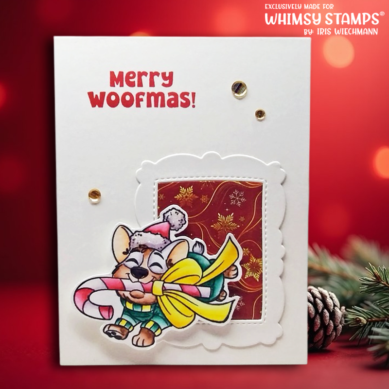 A handmade Christmas greeting card featuring the text 'Merry Woofmas!' in red, with a die cut illustration of a cartoon dog wearing a Santa hat while carrying a large yellow bow and candy cane. 