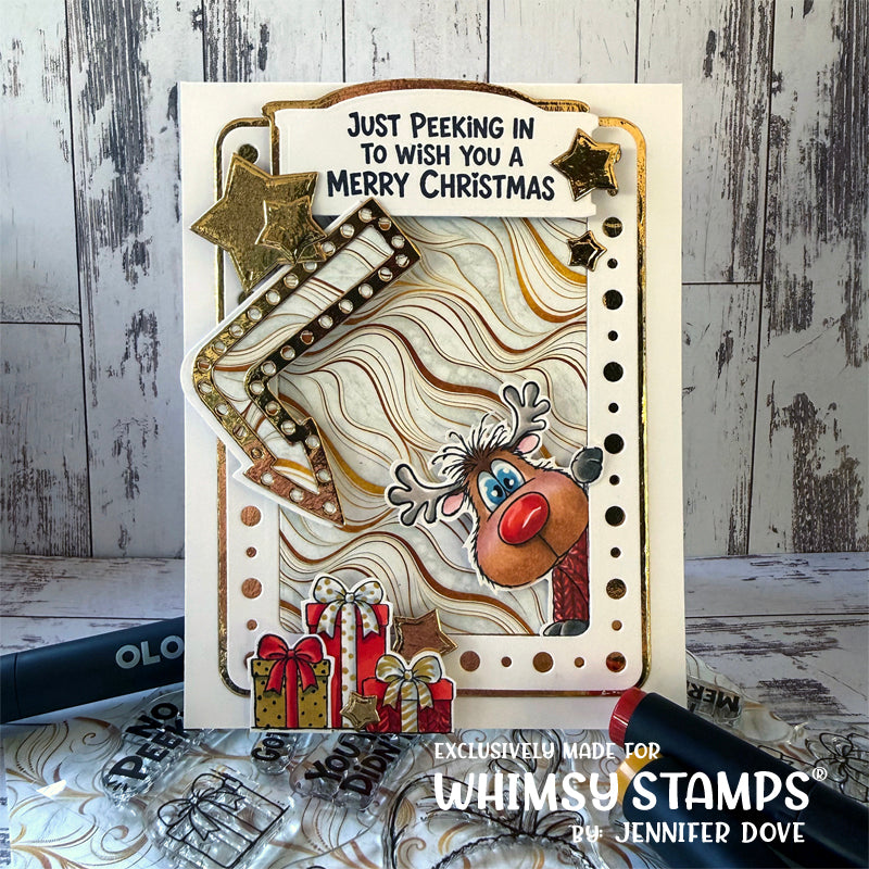 A Christmas greeting card featuring layered beige and brown textured paper, gold star embellishments, a reindeer face with a red nose, wrapped gifts, and the text 'Just Peeking In To Wish You A Merry Christmas.