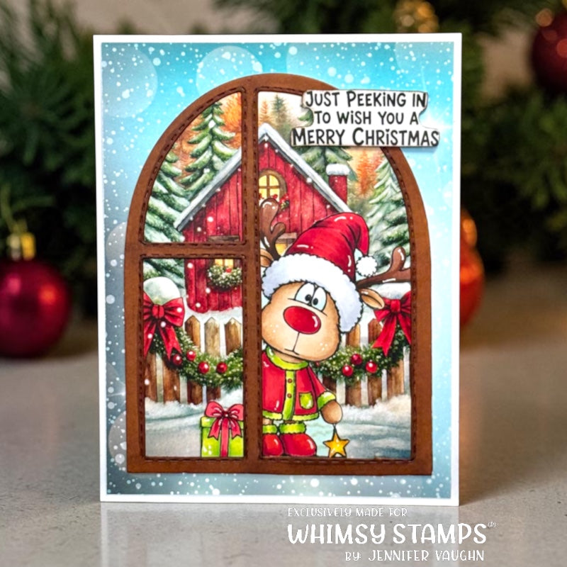 A handmade Christmas greeting card featuring a festive winter scene viewed through an arched window frame. The card shows a red barn, snow-covered trees, green garlands, a Santa-clad reindeer, and the text 'JUST PEEKING IN TO WISH YOU A MERRY CHRISTMAS.