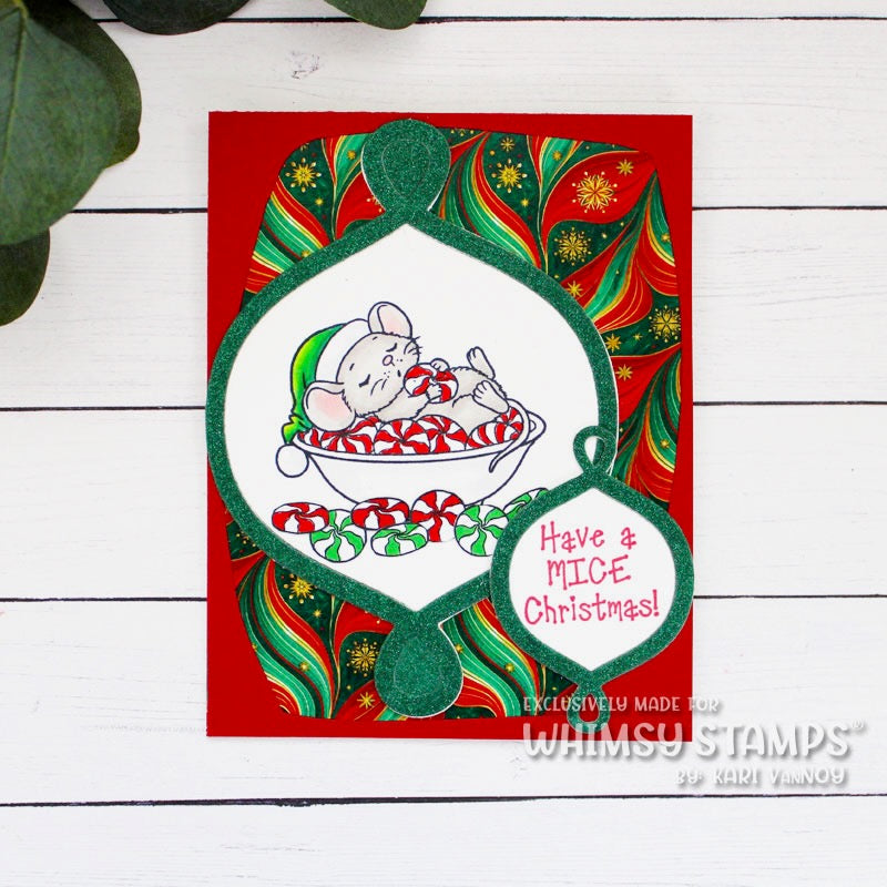 A handmade Christmas greeting card featuring a festive red background with green and red patterned papers and a die cut ornament, with the centerpiece showing a mouse in a candy dish, and the text 'Have a MICE Christmas!'. 
