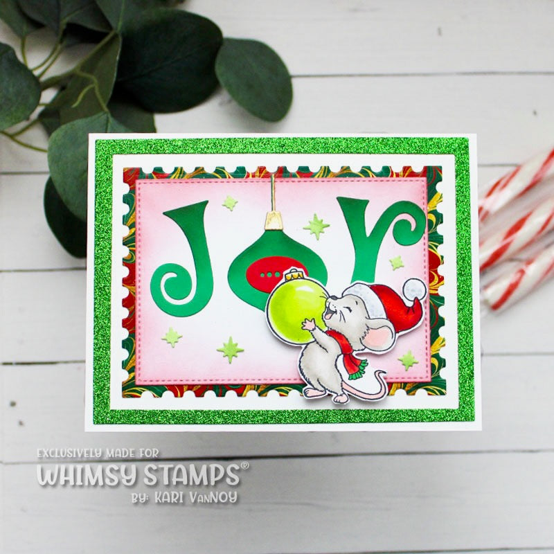 A handmade Christmas greeting card featuring the word 'Joy' in large green letters, a green ornament, a white mouse in a Santa hat, and a glittery green border.