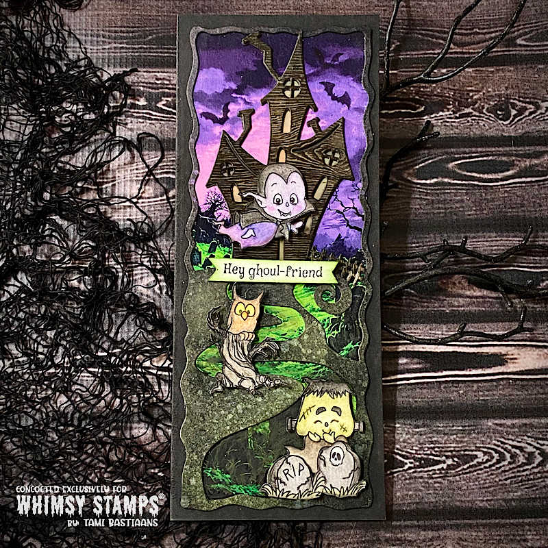 A handmade slimline Halloween card featuring a haunted house under a purple sky, a vampire ghost, an owl, and a Frankenstein character next to two gravestones.