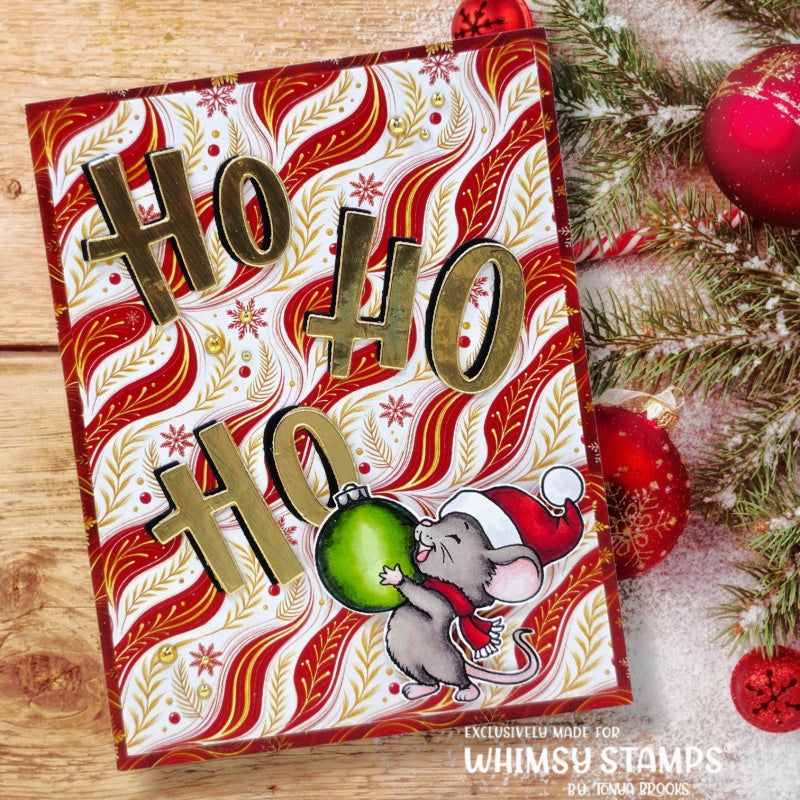 A festive handmade greeting card featuring 'HO HO HO' in metallic gold letters over a red, white, and gold patterned background, with a small gray mouse in a Santa hat holding a green ornament. 
