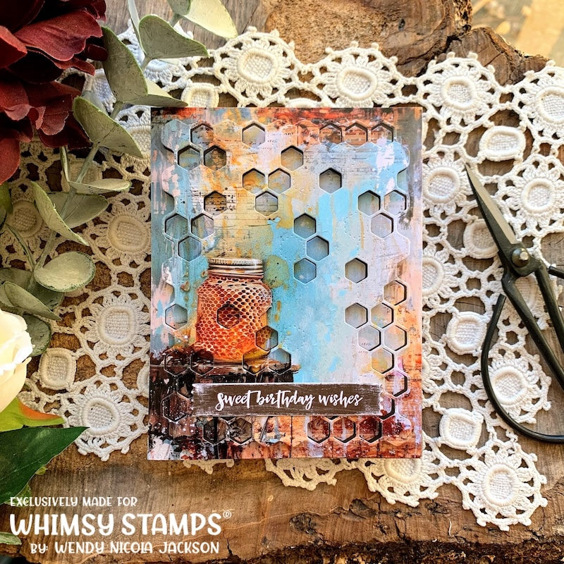 A handmade card featuring a mason jar of honey with vintage blue and yellow paper and a honeycomb pattern die-cut overlay. The sentiment 'Sweet Birthday Wishes' appears at the bottom center.